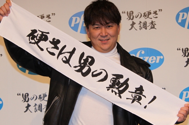 Daisuke Shima holding up a banner for Pfizer\'s \"Men\'s Hardness\" campaign in Japan